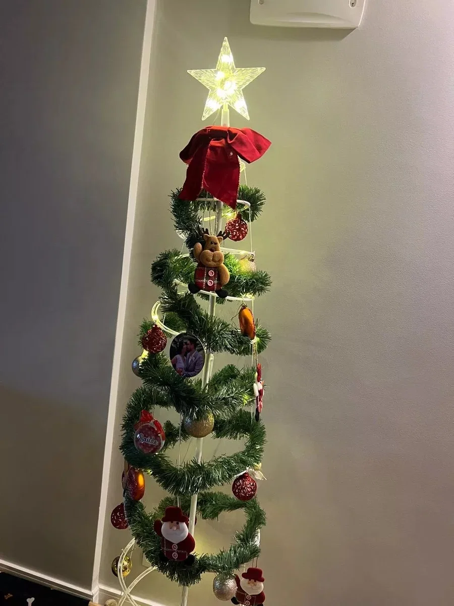 Árvore espiral decorada com festão verde e laço vermelho