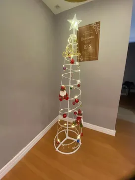 Árvore espiral com bolas vermelhas em um canto da sala